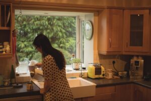 Woman preparing coffee in kitchen at home